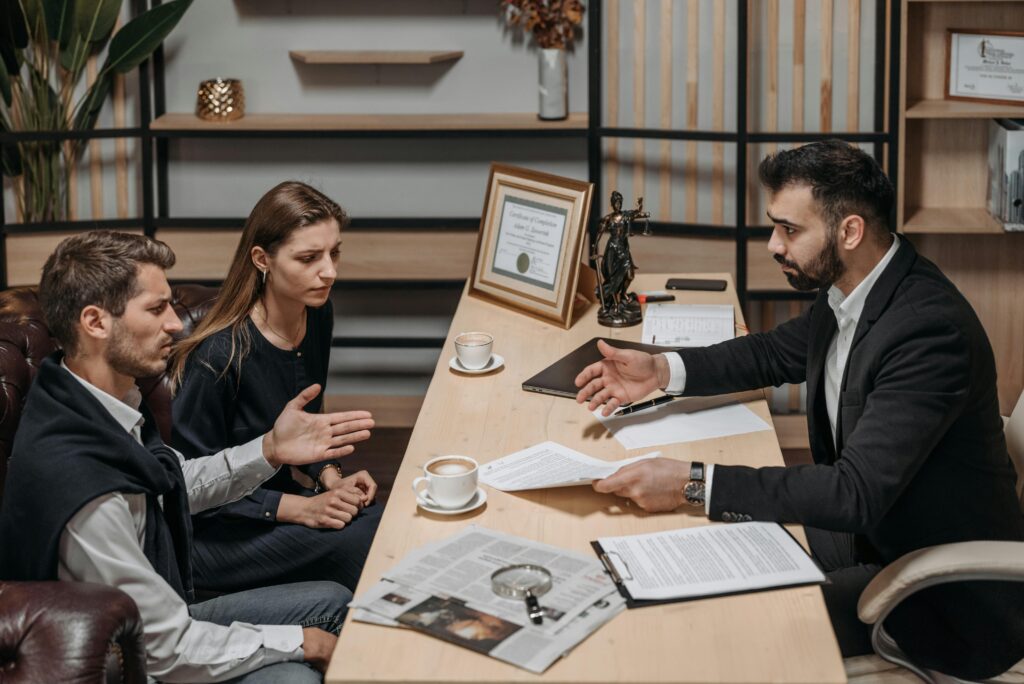 Officers consulting clients in an office, Documents and coffee on the table.